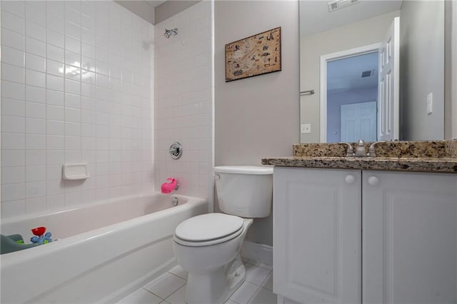 full bathroom featuring tile patterned flooring, vanity, tiled shower / bath combo, and toilet