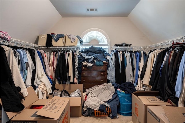 spacious closet with lofted ceiling and light carpet