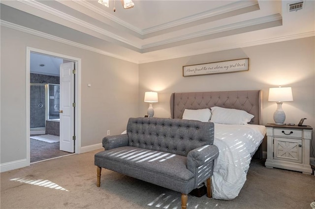 bedroom with crown molding, a tray ceiling, ensuite bathroom, and dark colored carpet