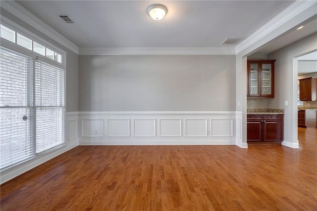 unfurnished room with crown molding and hardwood / wood-style floors