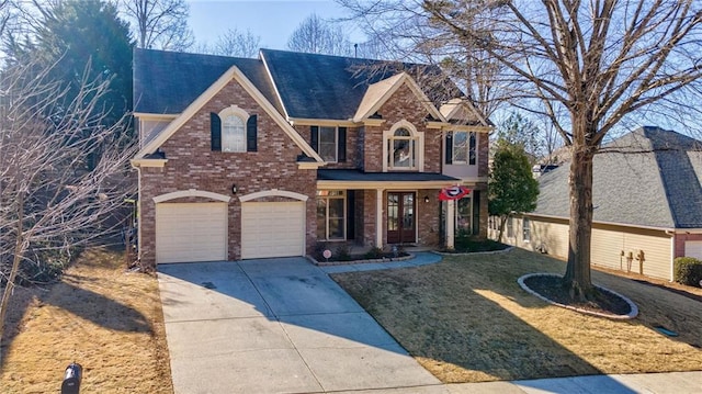 view of front property with a garage, covered porch, and a front lawn