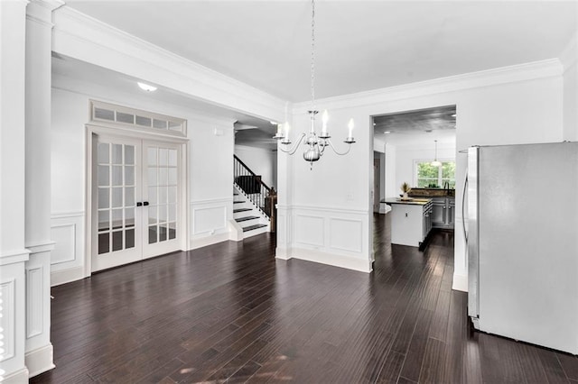 908 Rainsong Ct, Braselton, GA 30517 - unfurnished dining area featuring a chandelier, a decorative wall, dark wood finished floors, french doors, and stairs