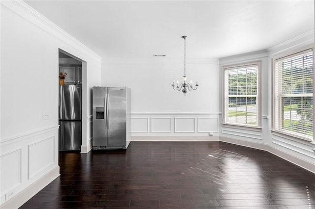 908 Rainsong Ct, Braselton, GA 30517 - unfurnished dining area featuring a chandelier, crown molding, a wainscoted wall, dark wood-type flooring, and a decorative wall