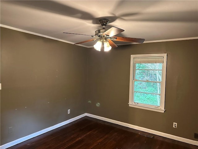 empty room with ornamental molding, dark wood-type flooring, ceiling fan, and baseboards