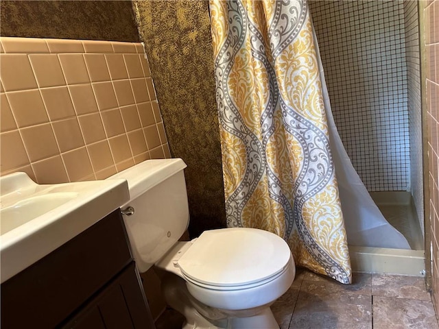 bathroom featuring tile walls, toilet, vanity, and a shower with curtain
