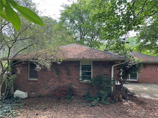 view of home's exterior with a patio and brick siding