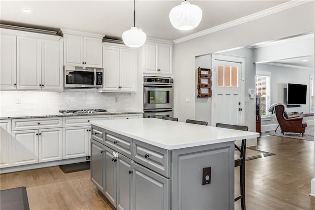 kitchen with gray cabinets, white cabinets, stainless steel appliances, and ornamental molding