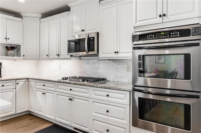 kitchen featuring backsplash, white cabinets, and appliances with stainless steel finishes