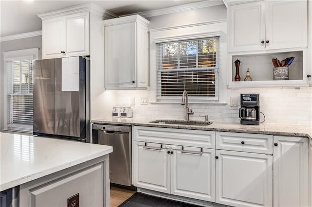 kitchen featuring a sink, crown molding, white cabinetry, and stainless steel appliances