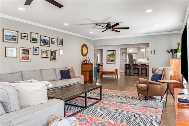 living area featuring crown molding, ceiling fan, and wood finished floors