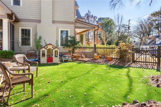 view of yard with a trampoline and fence