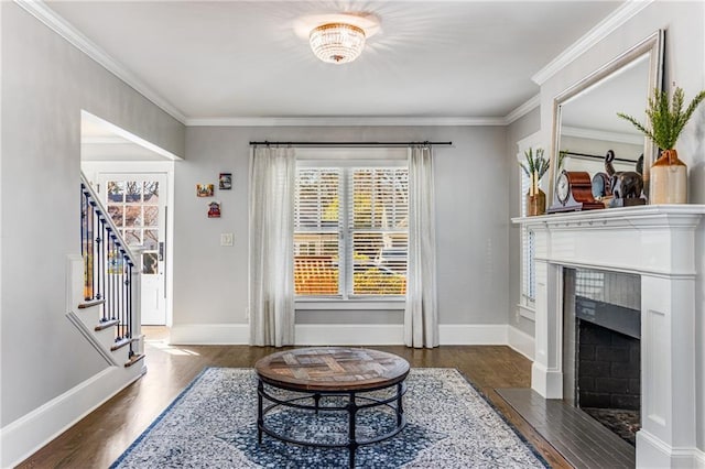 living area featuring stairs, wood finished floors, baseboards, and ornamental molding