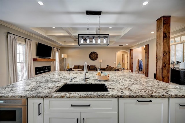 kitchen featuring sink, ornamental molding, white cabinets, and coffered ceiling