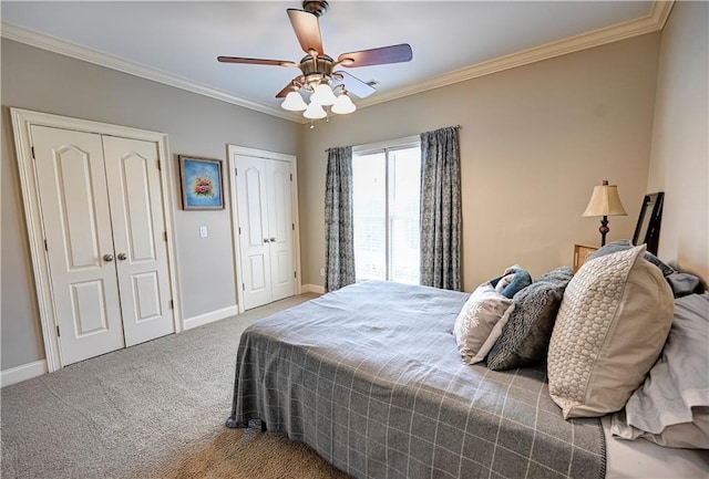 carpeted bedroom featuring crown molding, multiple closets, and ceiling fan