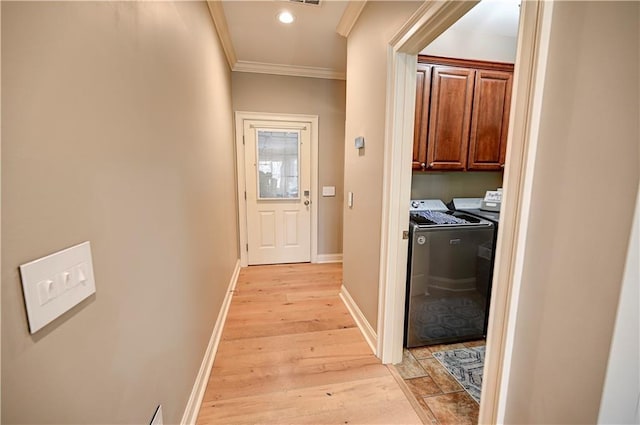 corridor with light wood-type flooring, crown molding, and washer and clothes dryer