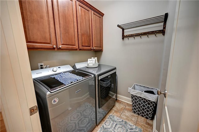 clothes washing area featuring washing machine and dryer and cabinets