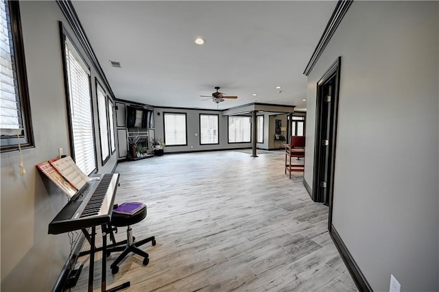 interior space with ceiling fan, light wood-type flooring, and crown molding