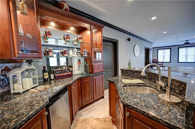 kitchen with sink, ceiling fan, dishwasher, dark stone counters, and crown molding