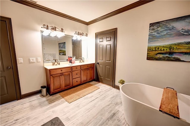 bathroom featuring hardwood / wood-style floors, a bath, vanity, and ornamental molding