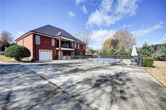 exterior space with a community pool, a balcony, and a garage