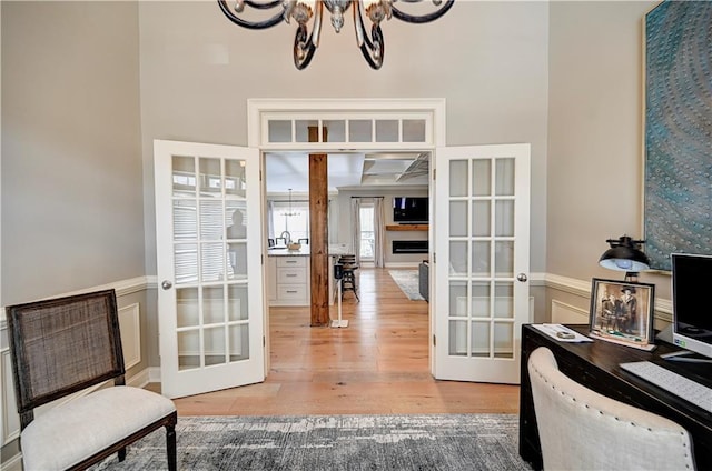 interior space with a notable chandelier, wood-type flooring, and french doors