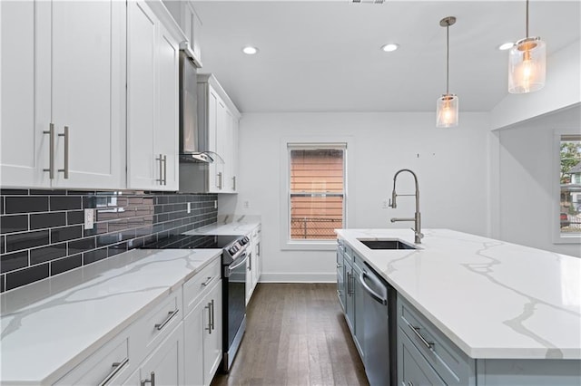 kitchen with sink, a kitchen island with sink, plenty of natural light, stainless steel appliances, and white cabinets