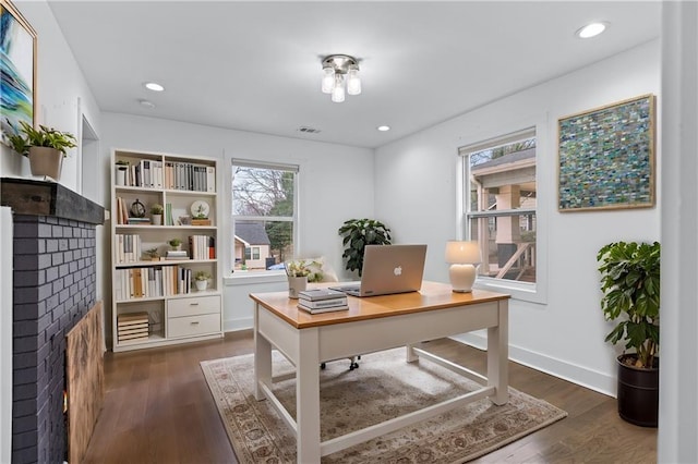 office area with dark hardwood / wood-style floors and a fireplace