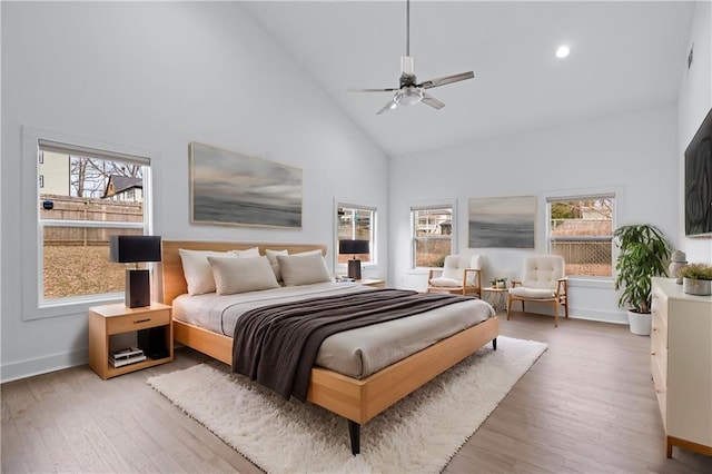 bedroom featuring high vaulted ceiling, light hardwood / wood-style floors, and ceiling fan