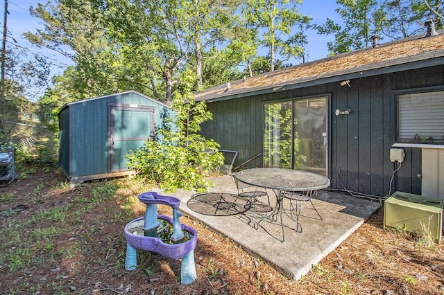 view of yard with a shed, a patio, and an outbuilding