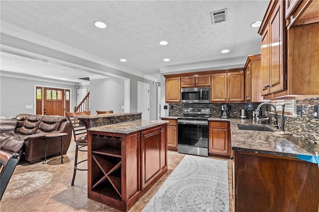 150 S St S, Buford, GA 30518 - kitchen with appliances with stainless steel finishes, a sink, ornamental molding, open floor plan, and a breakfast bar