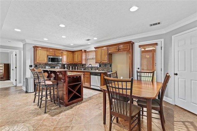 150 S St S, Buford, GA 30518 - kitchen with stainless steel appliances, decorative backsplash, crown molding, recessed lighting, and a kitchen island