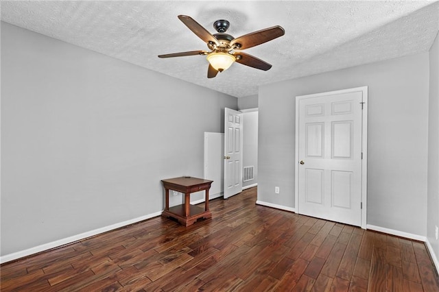 150 S St S, Buford, GA 30518 - unfurnished bedroom with dark wood finished floors, a textured ceiling, baseboards, and ceiling fan