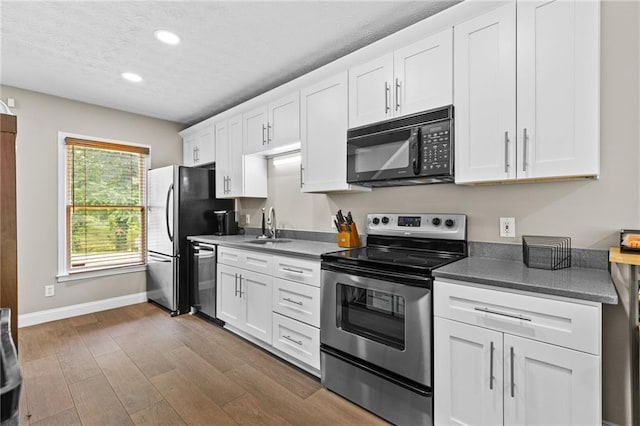 150 S St S, Buford, GA 30518 - kitchen featuring stainless steel appliances, recessed lighting, a textured ceiling, dark wood finished floors, and white cabinetry