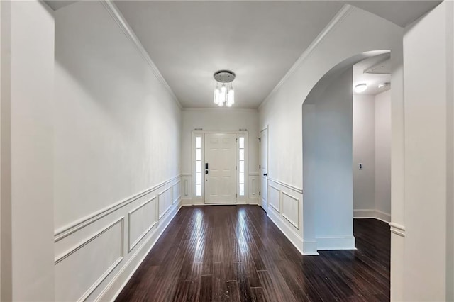 foyer entrance with ornamental molding and dark hardwood / wood-style floors