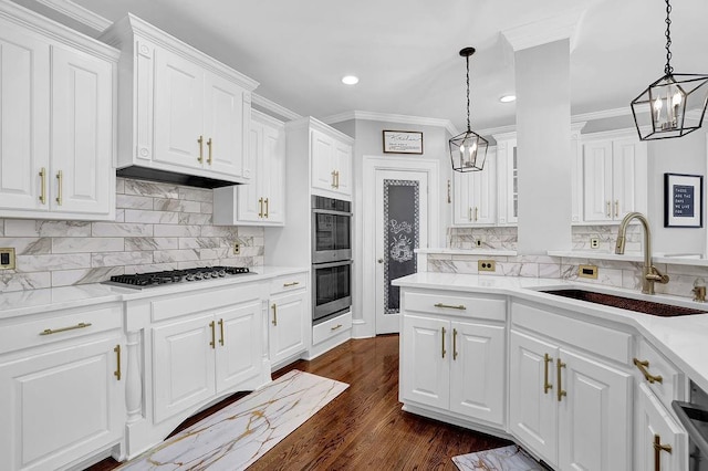 kitchen featuring appliances with stainless steel finishes, white cabinetry, sink, hanging light fixtures, and dark wood-type flooring