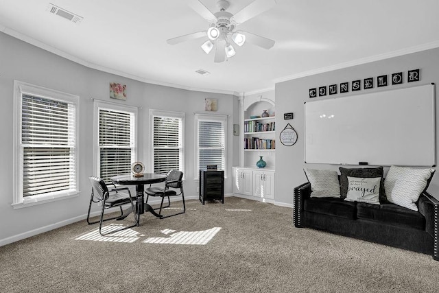 carpeted living room featuring ceiling fan, ornamental molding, and built in features