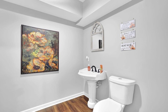 bathroom with hardwood / wood-style flooring and toilet