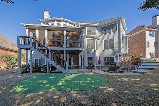 rear view of house with a patio and a sunroom