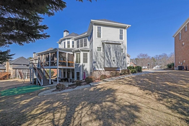 back of property featuring a sunroom and central AC