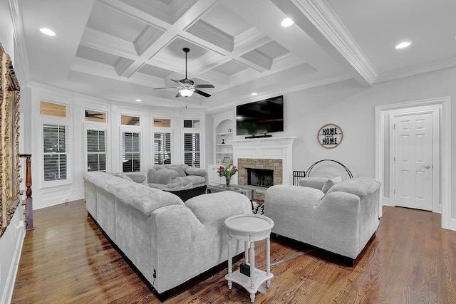 living room featuring a stone fireplace, dark hardwood / wood-style floors, beamed ceiling, coffered ceiling, and crown molding