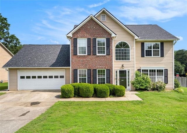 colonial house with driveway, a shingled roof, an attached garage, a front yard, and brick siding