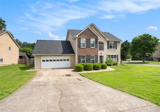 colonial house with concrete driveway, an attached garage, fence, a front lawn, and brick siding