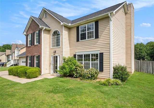 view of front of home with a garage, a chimney, fence, a front lawn, and brick siding