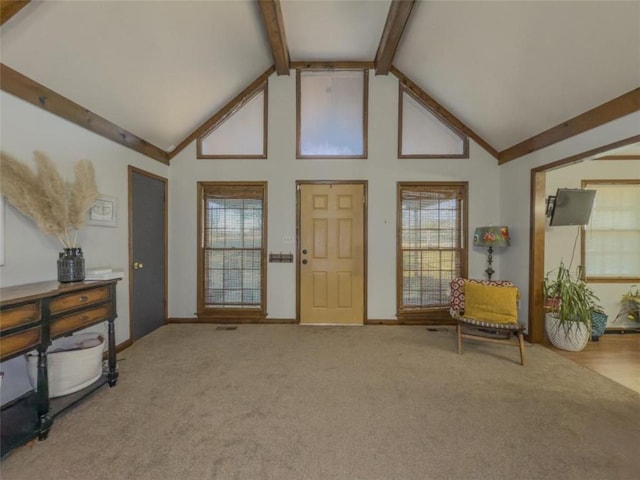 interior space with beamed ceiling, high vaulted ceiling, and carpet