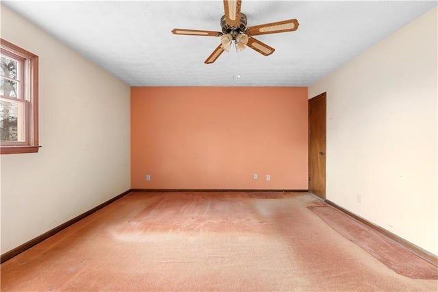 spare room featuring light carpet, ceiling fan, a textured ceiling, and baseboards