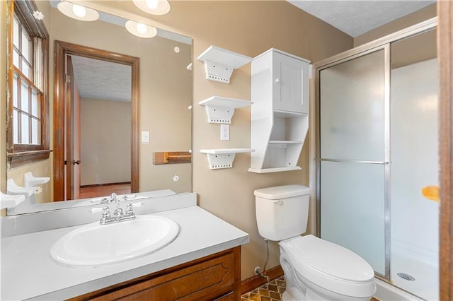 full bathroom featuring a textured ceiling, toilet, a shower stall, and vanity