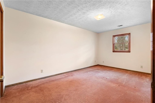 carpeted empty room featuring visible vents, a textured ceiling, and baseboards