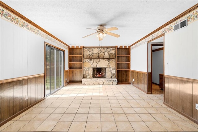 unfurnished living room with visible vents, crown molding, a textured ceiling, and a fireplace