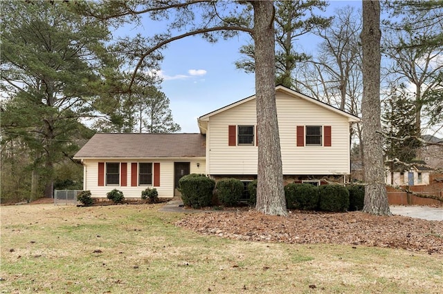 tri-level home with fence and a front lawn