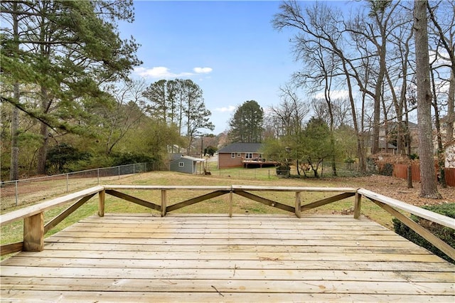 deck featuring a fenced backyard, a yard, and an outdoor structure